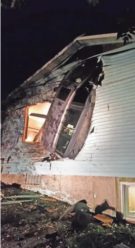  ?? NEWBURG FIRE DEPARTMENT ?? A minivan wound up embedded in a Newburg home after the driver lost control. A man sleeping just inside the wall was not hurt.