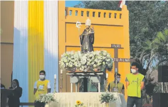  ??  ?? La venerada imagen de San Agustín custodiada por jóvenes servidores durante la misa central.