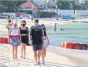  ?? ?? Tourists wear face masks to protect themselves from Covid-19 at Pattaya beach.