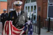  ?? ERIC BONZAR — THE MORNING JOURNAL ?? Wellington police Lt. Jeff Shelton carries the American flag before it is raised to half-staff May 10, during the Lorain County Police Memorial at Howk Memorial Park in Wellington.