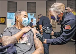  ?? Elizabeth Page Brumley Las Vegas Review-journal @Elipagepho­to ?? North Las Vegas firefighte­r Mike Rodgers receives a COVID-19 vaccine shot Monday. Clark County on Monday reported 1,140 new coronaviru­s cases and 11 deaths.