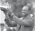  ?? MICHAEL MADRID/USA TODAY SPORTS ?? Tiger Woods celebrates with the green jacket and trophy after winning the Masters at Augusta National Golf Club last year.