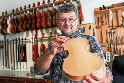  ??  ?? Der Greizer Geigenbaum­eister Gerd Mallon prüft den Boden einer im Bau befindlich­en Geige. Fotos (): Jens Büttner, dpa