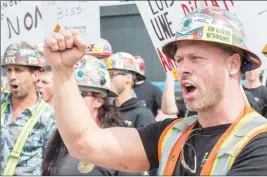  ?? CP PHOTO ?? Striking constructi­on workers form a picket line in front of a constructi­on site in Montreal yesterday.