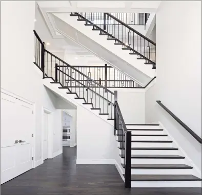  ??  ?? The double-height foyer, with a floating staircase ascending to the upper levels, is an inviting space to welcome guests to the home.