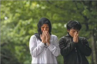  ?? Carl Court / Getty Images ?? People pray next to flowers and tributes on Tuesday near Al Noor mosque on March 19, 2019 in Christchur­ch, New Zealand.