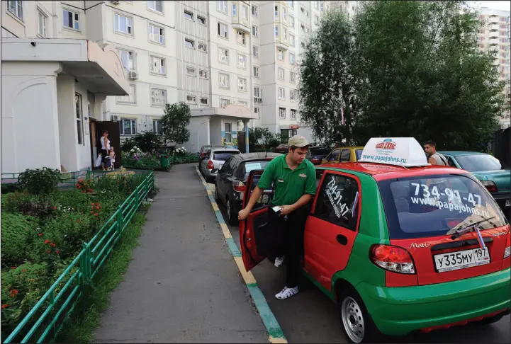  ?? JAMES HILL / NEW YORK TIMES FILE (2011) ?? A Papa John’s delivery driver arrives at an apartment complex in Moscow on July 24, 2011. The company has suspended its corporate operations in Russia.