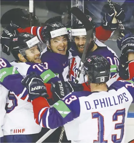  ?? Petr David Josek/ the associated press ?? Mike Hammond, centre, celebrates after scoring Great Britain’s first goal during the IIHF World Championsh­ips in a 6-3 loss to the United States in Kosice, Slovakia, Wednesday.