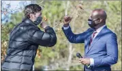  ?? MICHAEL HOLAHAN — THE ASSOCIATED PRESS ?? Jon Ossoff, left, and Raphael Warnock exchange elbow bumps during a campaign rally in Augusta, Ga., Monday.