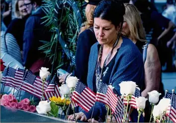  ?? Craig Ruttle / Associated Press ?? Julie Sweeney Roth, whose husband, Brian Sweeney Roth, died when United Airlines flight 175 hit the World Trade Center on Sept. 11, 2001, touches his inscribed name Saturday at the
National September 11 Memorial in New York on the 20th anniversar­y of the attacks.