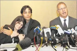  ?? Anne Cusack
Los Angeles Times ?? MICHAEL EGAN, center, hugs his mother, Bonnie Mound, as attorney Jeffrey Herman announces lawsuits against four Hollywood executives in April 2014.