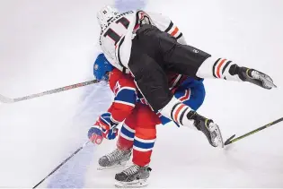  ?? PAUL CHIASSON/THE CANADIAN PRESS VIA AP ?? Chicago’s Andrew Desjardins (11) rolls over Montreal’s Alexei Emelin during the Blackhawks’ win Thursday in Montreal. The win was ninth in a row for Chicago.