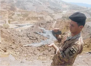  ?? MOHAMMED ZAATARI/AP ?? Israeli airstrikes: A Lebanese soldier displays part of an Israeli missile from an airstrike in Dimashqiya farmlands in southern Lebanon. Israel on Thursday escalated its response to rocket attacks this week by launching airstrikes overnight on Lebanon. A statement from the Israeli military said jets struck the launch sites from which the rockets were fired.