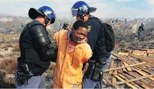  ?? PICTURE: PHANDO JIKELO ?? FORCE OF LAW: Police arrest a protester in Grabouw.