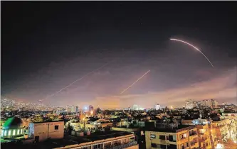  ?? HASSAN AMMAR THE ASSOCIATED PRESS ?? Missiles light up the Damascus skyline early Saturday as the U.S. and allies launch an attack on Syria.