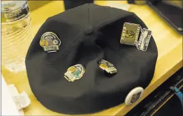  ?? Michael Quine ?? Las Vegas Review-journal @Vegas88s The hat of Knights fan Fernando Guzman, covered with playoff pins, rests on a table as Guzman gets a Knights logo shaved into the back of his head at the Goodtimes Barber Shop & Shave Parlor on May 25.