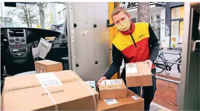  ?? FOTO: DETLEF ILGNER ?? DHL-Paketbote Janosch Dziwior steht an der Seitentür seines Fahrzeugs an der Hindenburg­straße und sortiert die vielen Pakete, die er noch ausliefern muss.