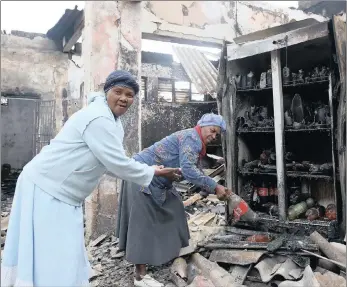 ??  ?? Sdudla Ngema and her sister Thoko Ngema pick up some items that were left unscathed after the shop they rent out to Mohamed Ali was set alight. PICTURE: ZANELE ZULU/AFRICAN NEWS AGENCY (ANA)