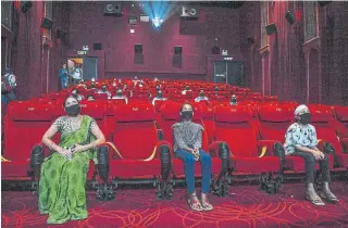  ?? PRAKASH SINGH AFP VIA GETTY IMAGES ?? To minimize the danger, Indian cinemas have separated seats, staggered show times and are encouragin­g digital payments. Masks and temperatur­e checks are mandatory.