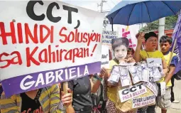  ?? (Camille Ante) ?? CASH TRANSFER FOR WHOM? – Members of Grabriela stage a protest rally in front of the Department of Social Welfare and Developmen­t (DSWD) main office in Batasan Road, Quezon City, questionin­g the proposed  104.5-billion budget of the agency which they...