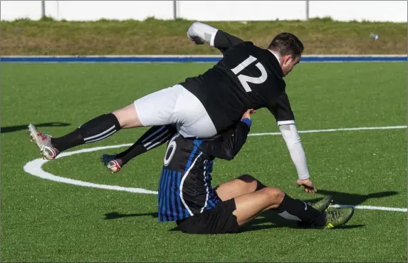  ?? Photo by Domnick Walsh / Eye Focus ?? Head over heels: David Kerins, Windmill United in action against and Gyalso Sangye , Inter Kenmare during their Denny Premier B clash at Mounthawk Park