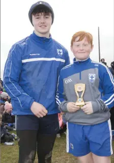  ??  ?? Best Senior Boy of the Camp Dylan Keogh is presented with his award by David Williamson at the Blessingto­n GAA Easter Camp.