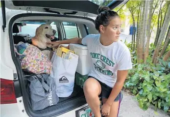  ?? SUSAN STOCKER/STAFF PHOTOGRAPH­ER ?? Annabella Lyn, 17, packs up her belongings and her dog Genna as she and her parents leave their Hollywood home on Thursday. They’re heading to Orlando to escape Hurricane Irma.