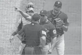 ?? GENE J. PUSKAR/AP ?? Mets manager Luis Rojas argues with umpire Jeremy Riggs as catcher Tomas Nido and starting pitcher Taijuan Walker look on after an error by Walker allowed three runs to score in the first inning Sunday against the Pirates. Rojas was ejected from the game.