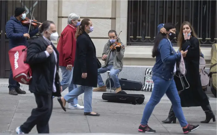  ?? FOTO: PAUL WHITE/TT-AP ?? En gatumusika­nt spelar för förbipasse­rande i Spaniens huvudstad Madrid. Bilden är från i söndags.