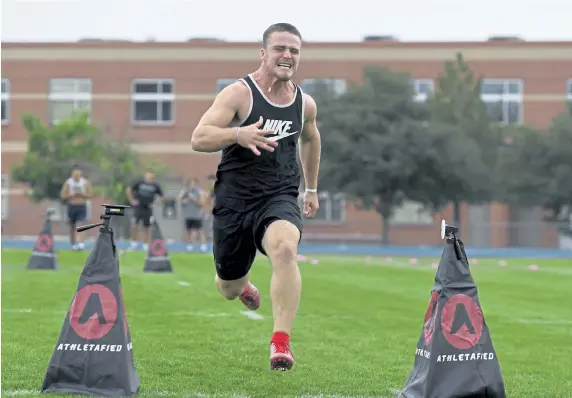  ?? Photos Andy Cross, The Denver Post ?? Northridge High School linebacker Aaron Kness pushes hard at the finish of the 40- yard dash during a high school combine at Mullen High School on Friday. Over 150 Colorado high school football players were able to gather performanc­e data at the combine to show college scouts.