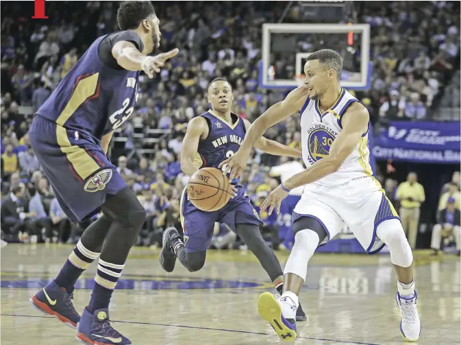  ?? — AP ?? OAKLAND: Golden State Warriors’ Stephen Curry, right, passes away from New Orleans Pelicans’ Anthony Davis, left, and Tim Frazier (2) during the second half of an NBA basketball game Monday, in Oakland, Calif.