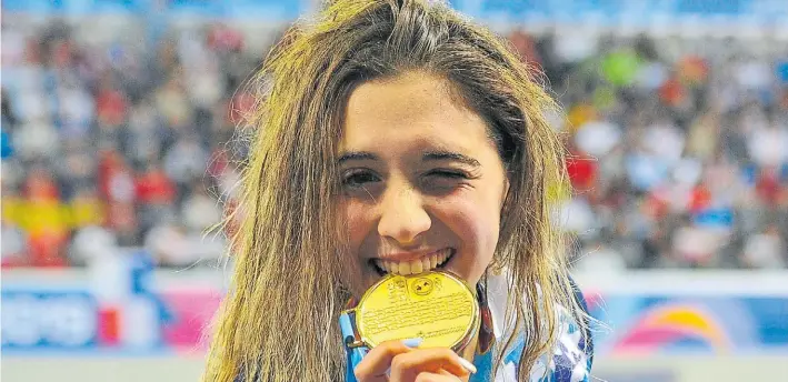  ?? FOTOS: MAXI FAILLA ?? Dorada. Delfina Pignatiell­o y la medalla que consiguió en los 400 metros libre. La gran promesa de la natación argentina competirá en los 800 y los 1.500 libre.