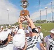  ?? KENNETH K. LAM/BALTIMORE SUN ?? Loyola Maryland players celebrate with the Patriot League championsh­ip trophy. “They’re playing their best lacrosse right now, and that’s exciting,” coach Charley Toomey said.