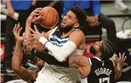  ?? MARK J. TERRILL/AP ?? Karl-anthony Towns, center, can’t escape the defense of Paul George and Kawhi Leonard during Sunday’s 124-105 Clippers win over Minnesota.