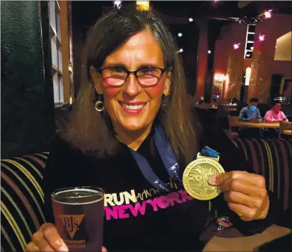  ?? COURTESY PHOTO ?? Cupertino resident Barb Love enjoys a beer after completing a re-creation of the New York City Marathon along the Peninsula. A crew of 18 friends devised the local marathon after the actual event was cancelled due to the pandemic. Love wore bib No. 632, a nod to her sixth NYC marathon and her 32nd marathon overall.