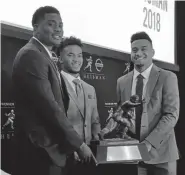  ?? Ralph Russo, The Associated Press ?? From left, Ohio State’s Dwayne Haskins, Oklahoma’s Kyler Murray and Alabama’s Tua Tagovailoa pose with the Heisman Trophy at the New York Stock Exchange on Friday.