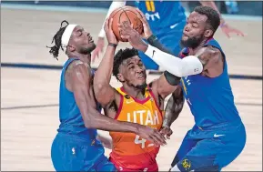  ?? ASHLEY LANDIS/ AP PHOTO ?? Utah’s Donovan Mitchell goes up to shoot as Denver’s Jelami Grant, left, and Paul Millsap defend during an NBA Western Conference playoff game on Aug. 30 in Lake Buena Vista, Fla.