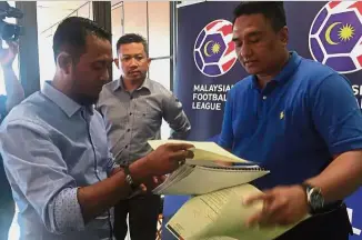  ??  ?? All in order: Perlis FA deputy president Mohd Abdul Karim Khan Mansor Ahmad Khan (left) handing their appeal documents to Malaysia Football League (MFL) chief operating officer Mohd Shazli Shaik Mohd at their headquarte­rs yesterday.