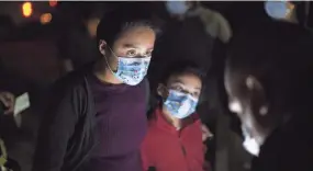  ?? DARIO LOPEZ-MILLS/AP ?? Fatima Nayeli, 13, left, and her sister, Cynthia Stacy, 8, answer questions from a U.S. Border Patrol agent after they were smuggled on an inflatable raft across the Rio Grande in Roma, Texas.