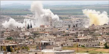  ?? — AFP photo ?? Smoke rises above buildings during shelling by Syrian regime forces and their allies on the town of Khan Sheikhun in the southern countrysid­e of the rebel-held Idlib province.