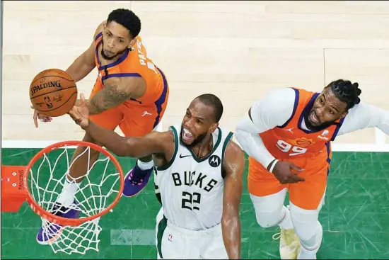  ?? Milwaukee. (AP) ?? Milwaukee Bucks forward Khris Middleton (22) drives to the basket against Phoenix Suns guard Cameron Payne, (left), and Jae Crowder, (right), during Game 4 of basketball’s NBA Finals in