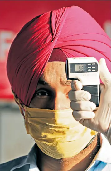  ??  ?? A man has his temperatur­e checked as he arrives at Amritsar railway station ahead of the resumption of interstate services
