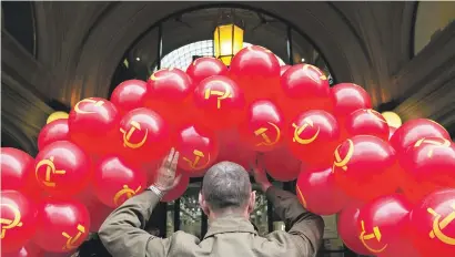  ?? Pictures: AFP ?? RED TIDE. A Russian Communist Party activist holds up balloons during the traditiona­l May Day rally yesterday in Moscow.