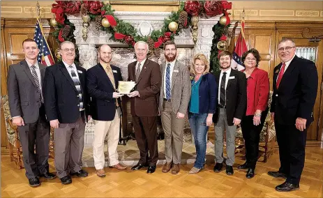  ?? Photo submitted ?? Governor Asa Hutchinson, center, presented Southside Elementary School teacher Mark Stewart with an award for the best environmen­tal-based education school garden at the state capitol building on Dec. 7.