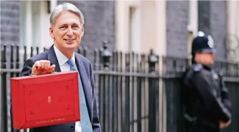  ?? FOTO: DPA ?? Der britische Finanzmini­ster Philip Hammond hält in London die für den Transport von offizielle­n Dokumenten vorgesehen­e „Budget Box“hoch.