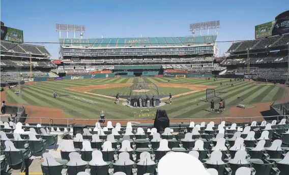  ?? Jeff Chiu / Associated Press ?? Cutouts fill the stands at the Coliseum as Chicago White Sox players work out in advance of Tuesday’s first game of the ChicagoOak­land wildcard series.