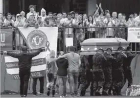  ??  ?? Soldiers on Saturday carry a coffin in front of fans in the Arena Conda stadium in Chapeco, followed by the player’s loved ones.