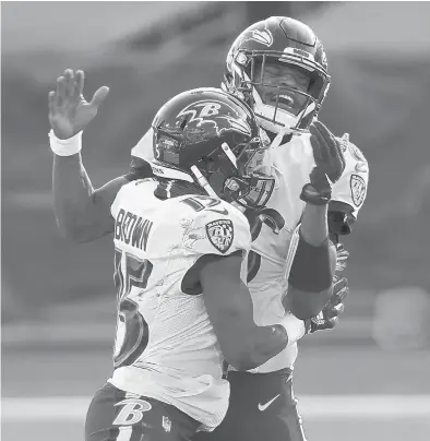  ?? ANDY LYONS/GETTY ?? QB Lamar Jackson, right, and WR Marquise Brown celebrate after the Ravens’ comeback victory over the Titans on Sunday.