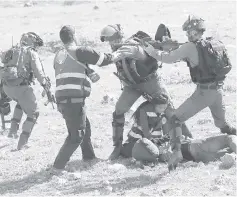  ?? — AFP photo ?? Israeli soldiers scuffle with Palestinia­n Civil Defence volunteers in the West Bank town of Birzeit, near Ramallah.