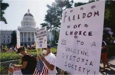  ?? Rich Pedroncell­i / Associated Press ?? Protesters opposing vaccine mandates, which could be advanced again next year, march past the Capitol.